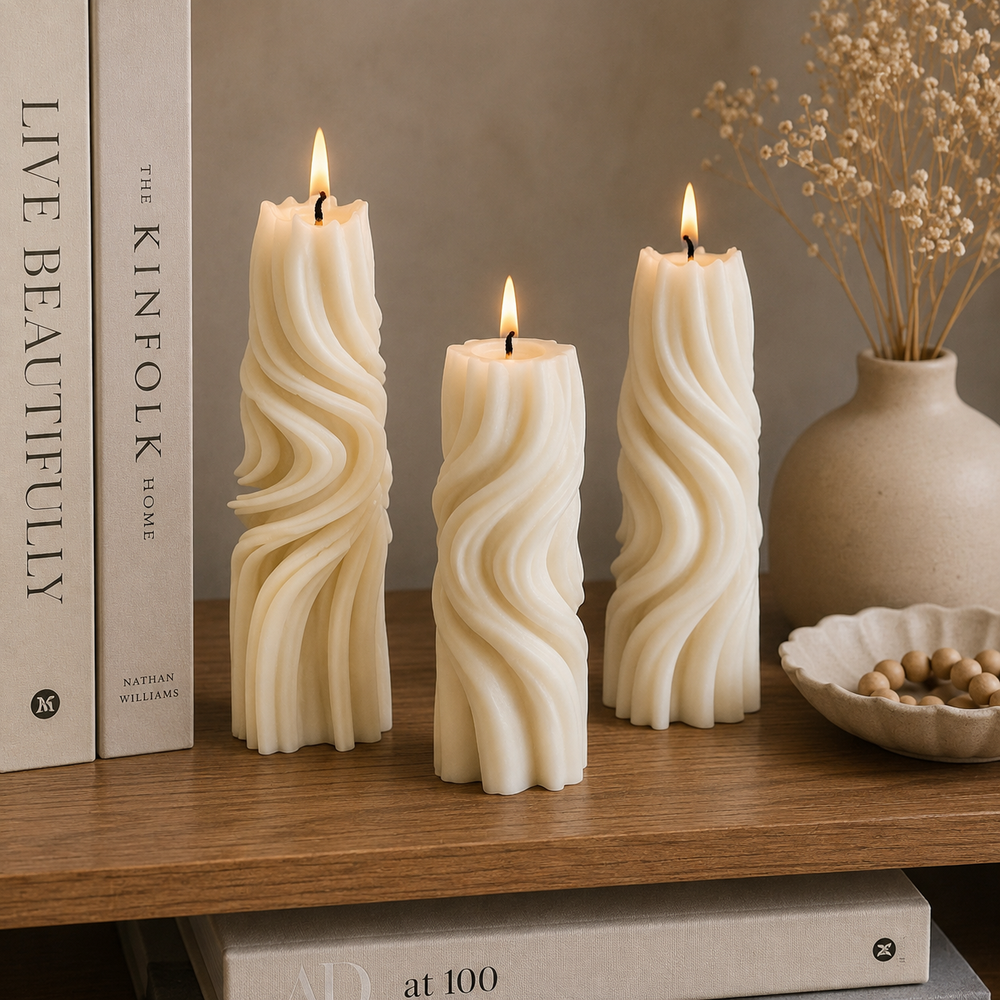 Three cream-colored twisted pillar candles with lit flames are arranged on a wooden shelf next to books and a ceramic vase with dried flowers.
طقم شموع ديكور مودرن مكون من 3 شموع بتصميم حلزوني وأحجام مختلفة باللون الكريمي لتزيين الكونسول والأرفف.
