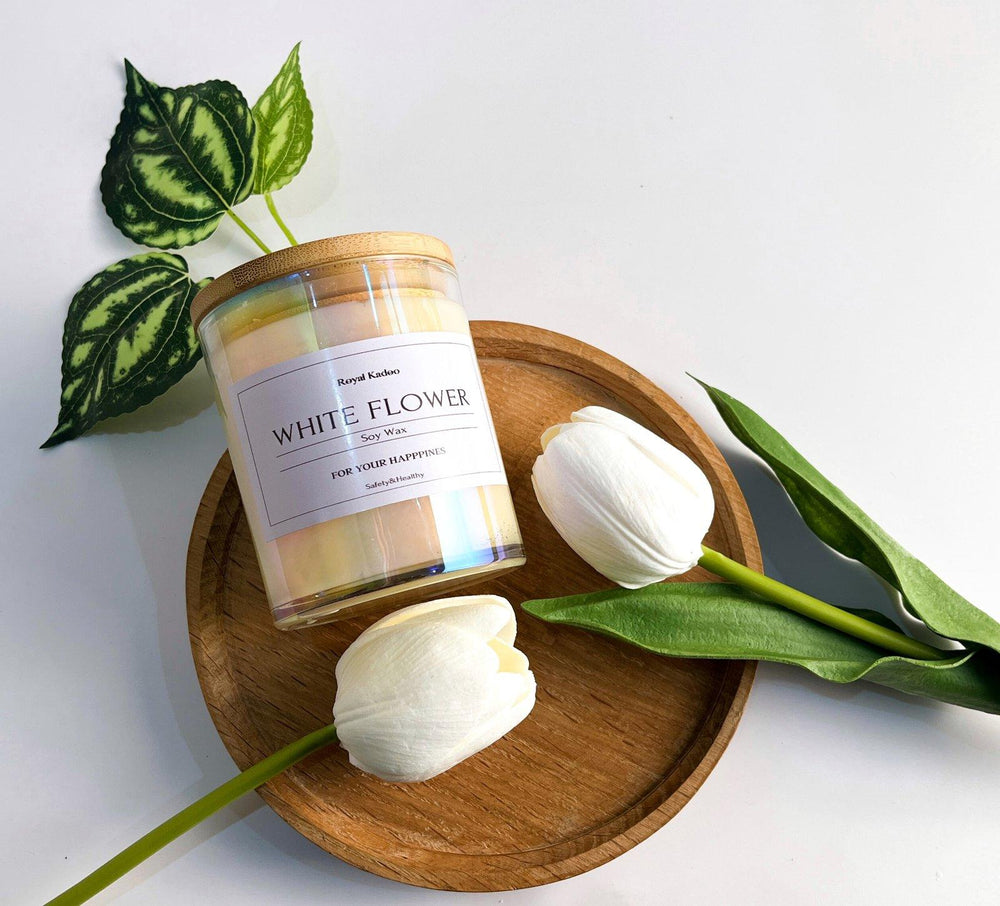 Candle labeled 'White Flower' on a wooden plate with white tulips and green leaves.
شمعة وايت فلاور معطرة من شمع الصويا داخل عبوة زجاجية بغطاء خشبي، موضوعة على صينية خشبية بجوار زهور توليب بيضاء وأوراق خضراء.