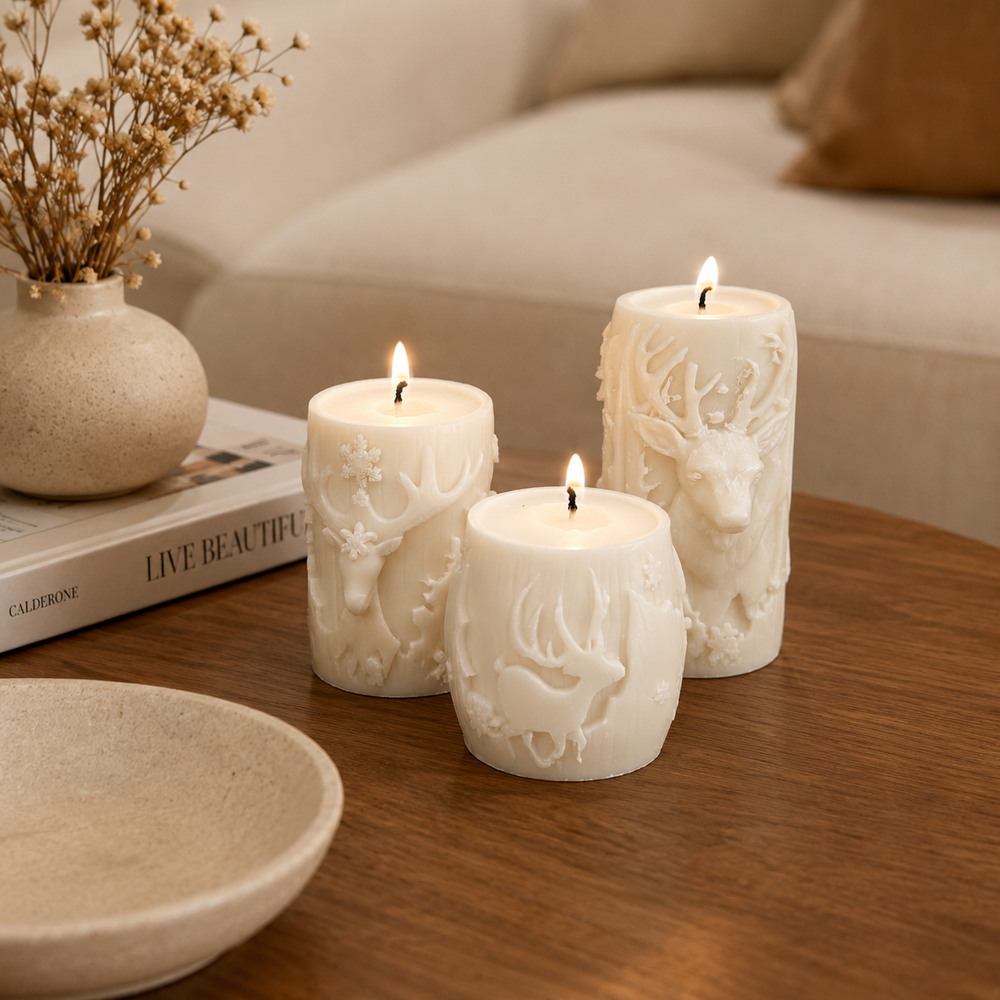 Three white wax candles with embossed deer and snowflake designs, lit and displayed on a wooden table in a cozy indoor setting.
طقم 3 شموع كريمي بتصميم الغزال الشتوي وتفاصيل بارزة بأحجام مختلفة لتزيين الكونسول وطاولة القهوة وديكور المنزل.